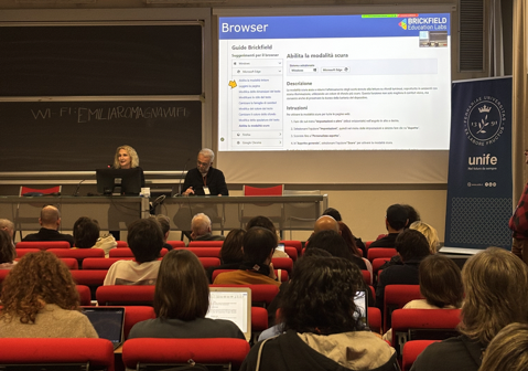 Audience seated in a lecture hall watching a presentation slide about browser accessibility tools, by Brickfield Education Labs.